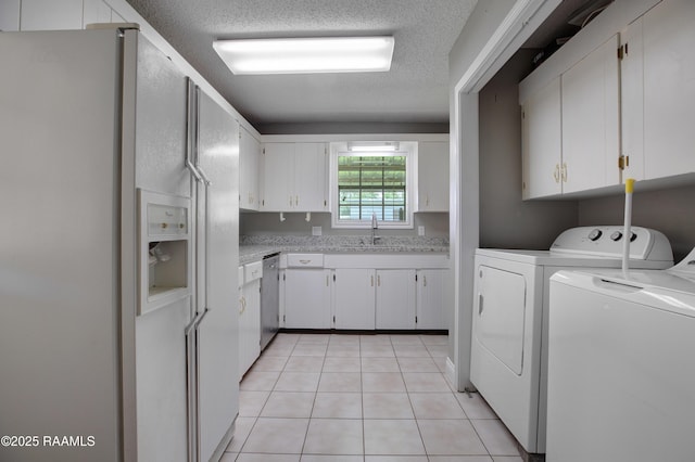 1406 S Patout St, New Iberia, LA 70560 - washroom with independent washer and dryer, laundry area, a sink, a textured ceiling, and light tile patterned floors