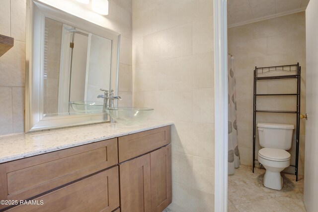 1406 S Patout St, New Iberia, LA 70560 - bathroom featuring tile walls, tile patterned floors, vanity, toilet, and ornamental molding