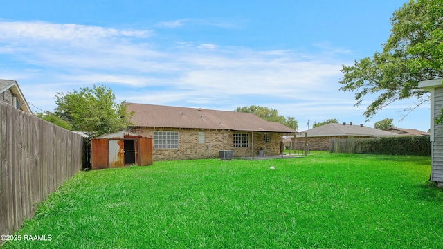 1406 S Patout St, New Iberia, LA 70560 - view of yard with a storage unit, a fenced backyard, an outbuilding, and central AC unit