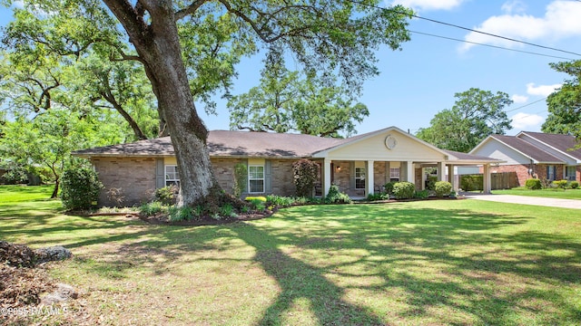 200 Sandager Ave, Jeanerette, LA 70544 - view of front of house with concrete driveway, brick siding, and a front lawn
