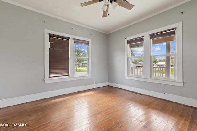 spare room with baseboards, ceiling fan, ornamental molding, and hardwood / wood-style flooring