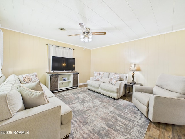 living area with ceiling fan, ornamental molding, wood finished floors, and visible vents
