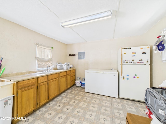 clothes washing area with light floors, a sink, and cabinet space