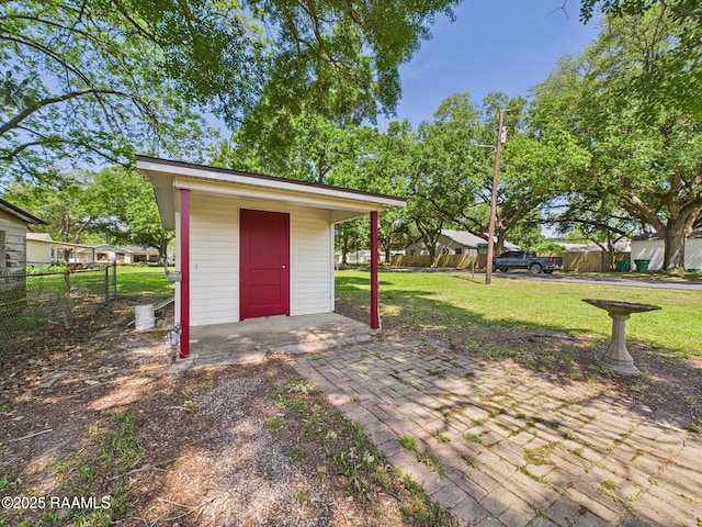 view of patio / terrace featuring an outbuilding and fence