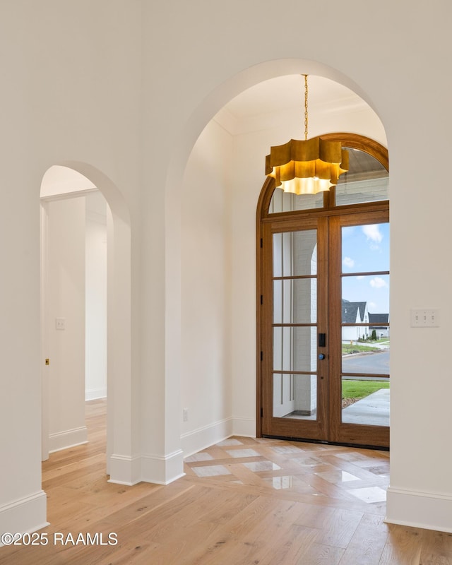 207 Sunset Palm Ct, Youngsville, LA 70592 - entrance foyer featuring wood finished floors, arched walkways, a chandelier, and french doors