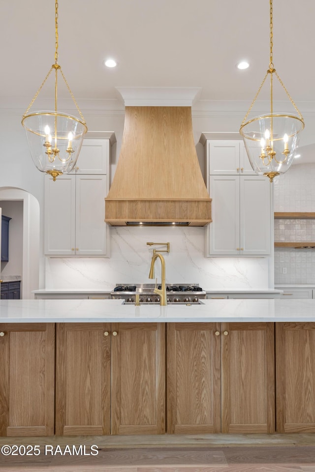 207 Sunset Palm Ct, Youngsville, LA 70592 - kitchen with a chandelier, premium range hood, backsplash, hanging light fixtures, and ornamental molding