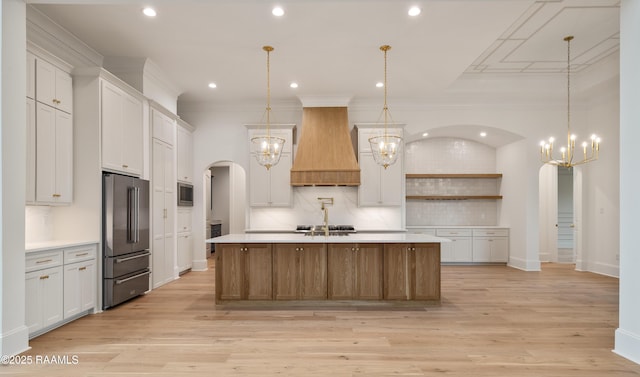 207 Sunset Palm Ct, Youngsville, LA 70592 - kitchen with appliances with stainless steel finishes, custom range hood, light countertops, a chandelier, and ornamental molding