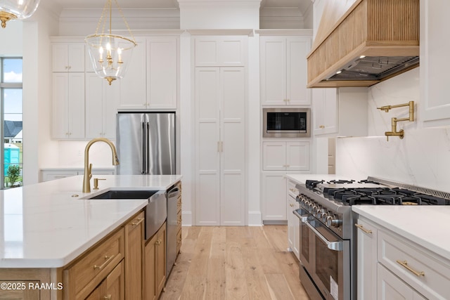 207 Sunset Palm Ct, Youngsville, LA 70592 - kitchen featuring stainless steel appliances, custom exhaust hood, light wood finished floors, crown molding, and light countertops