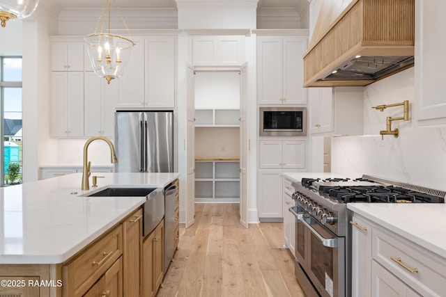 207 Sunset Palm Ct, Youngsville, LA 70592 - kitchen featuring appliances with stainless steel finishes, custom range hood, light wood-style flooring, white cabinets, and ornamental molding