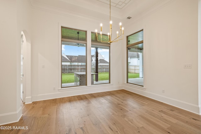 207 Sunset Palm Ct, Youngsville, LA 70592 - unfurnished dining area featuring ornamental molding, a chandelier, wood finished floors, and arched walkways