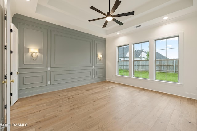 207 Sunset Palm Ct, Youngsville, LA 70592 - empty room featuring a tray ceiling, a ceiling fan, light wood-style flooring, and recessed lighting