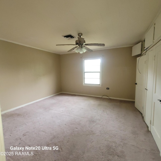 empty room featuring crown molding, baseboards, visible vents, and a ceiling fan