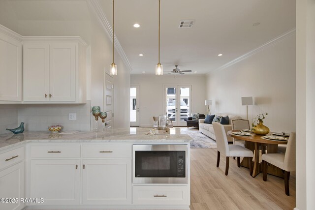 1510 Kaliste Saloom Unit 201, Lafayette, LA 70508 - kitchen with crown molding, white cabinets, built in microwave, visible vents, and light wood finished floors