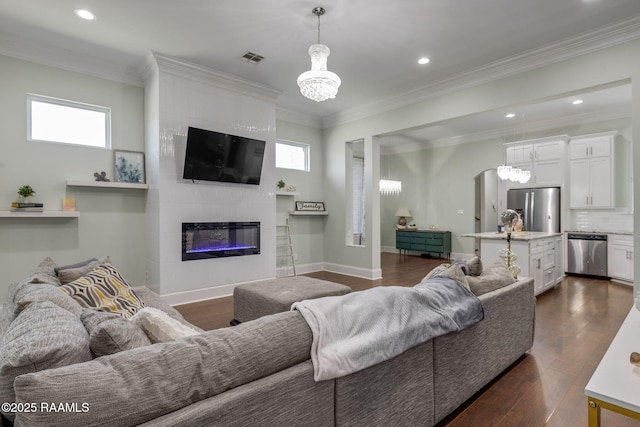 208 Woodstone Dr, Lafayette, LA 70508 - living area featuring an inviting chandelier, a fireplace, dark wood finished floors, and a wealth of natural light