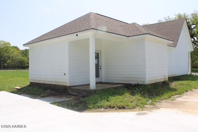 view of property exterior with a shingled roof