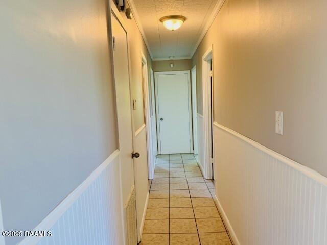 336 Harmon Ln, Opelousas, LA 70570 - hallway featuring ornamental molding, light tile patterned flooring, and attic access