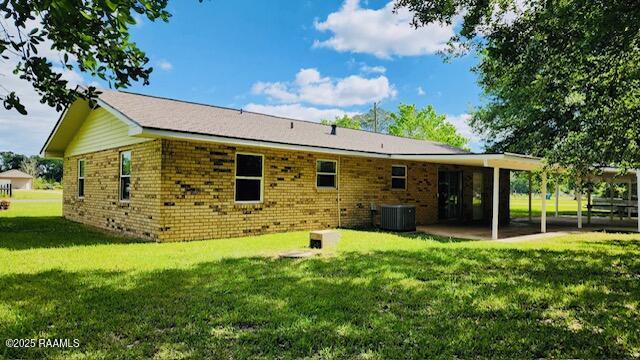 336 Harmon Ln, Opelousas, LA 70570 - rear view of property with a lawn, cooling unit, a patio area, and brick siding
