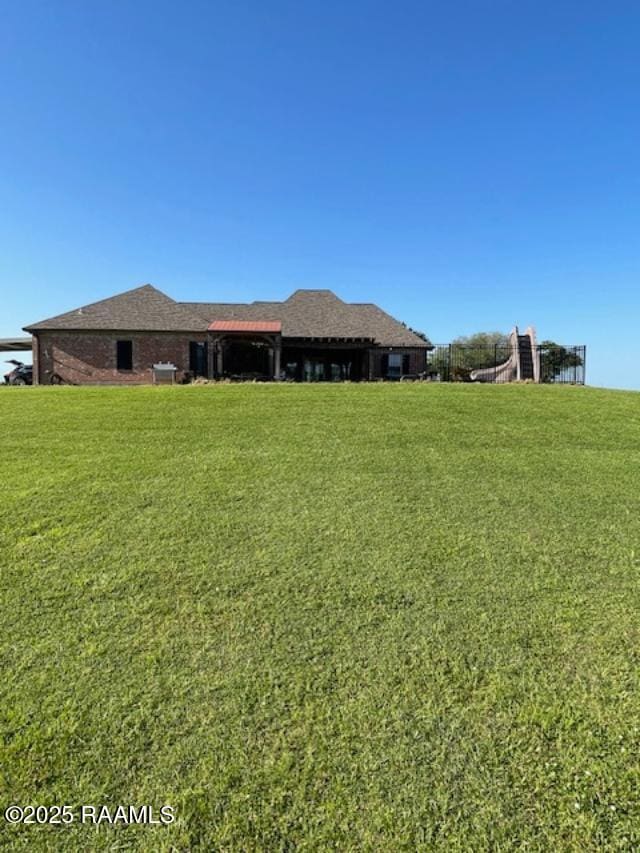 rear view of house featuring a yard