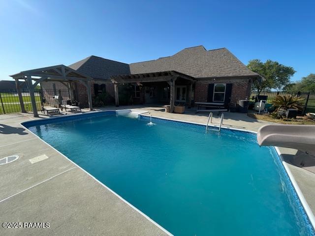 view of pool featuring a water slide, fence, a patio, and a pergola