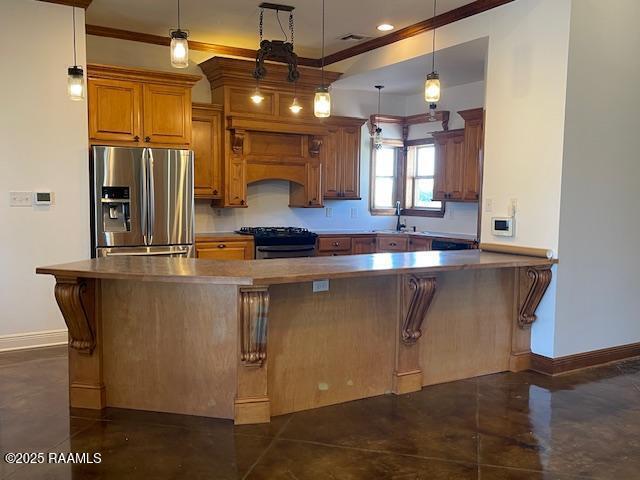 kitchen featuring appliances with stainless steel finishes, ornamental molding, a sink, baseboards, and brown cabinetry