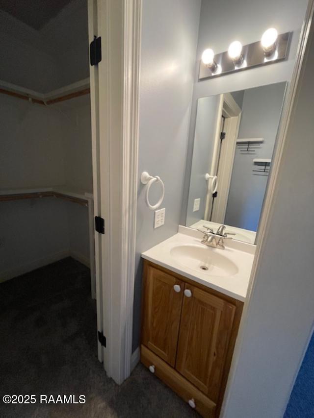 bathroom featuring vanity and a walk in closet