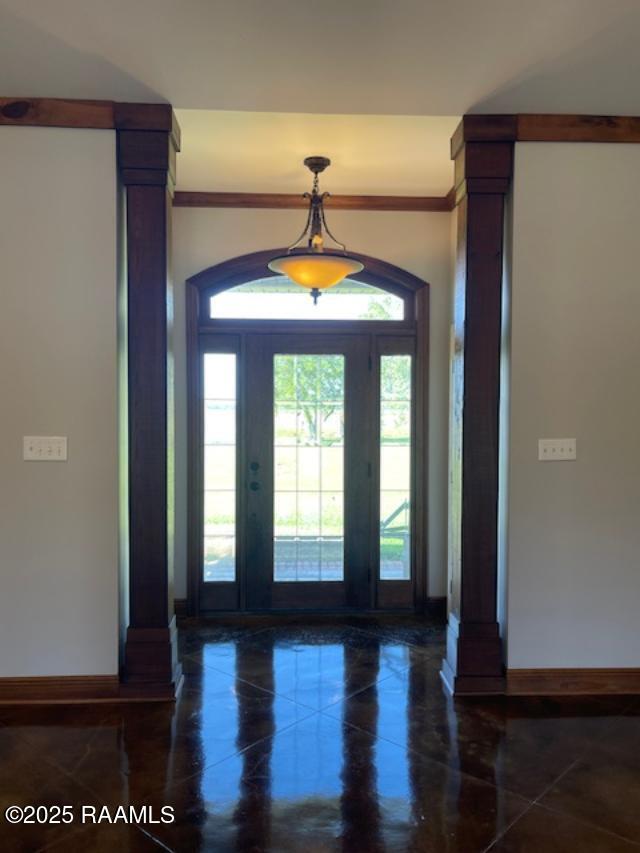 entrance foyer featuring baseboards, tile patterned floors, and ornamental molding