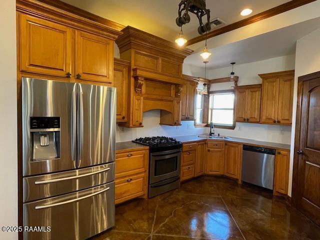 kitchen featuring appliances with stainless steel finishes, a sink, brown cabinets, hanging light fixtures, and crown molding