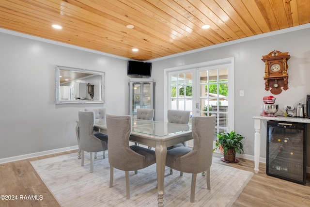 dining area featuring crown molding, wooden ceiling, and beverage cooler