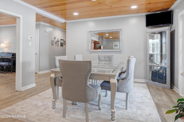 dining area featuring wood ceiling, wood finished floors, and crown molding