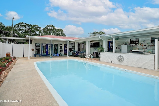 outdoor pool with a patio area and fence