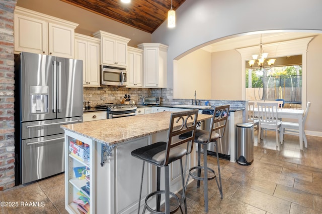 kitchen with stainless steel appliances, a sink, arched walkways, an inviting chandelier, and wooden ceiling