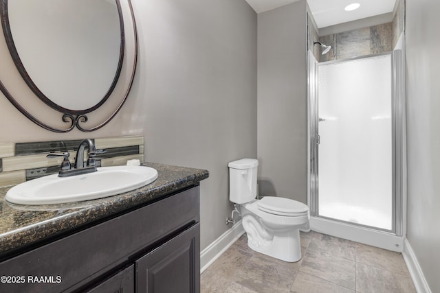 bathroom with baseboards, toilet, vanity, and walk in shower