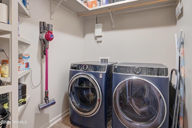 laundry area with washing machine and clothes dryer, baseboards, and laundry area