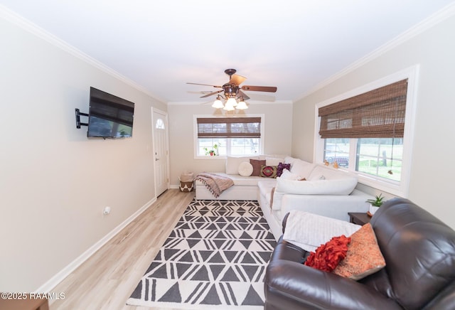 living room with plenty of natural light, light wood-style flooring, baseboards, and crown molding