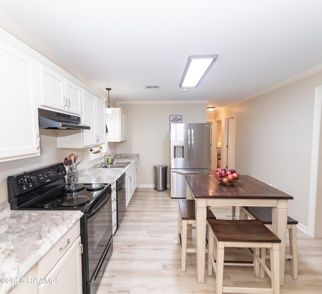 kitchen with white cabinets, under cabinet range hood, black appliances, light wood finished floors, and a sink