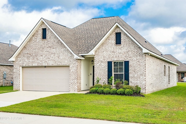 view of front of home with a front lawn, driveway, brick siding, an attached garage, and a shingled roof
