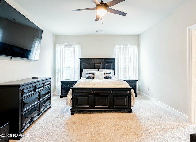 bedroom with visible vents, baseboards, and light carpet