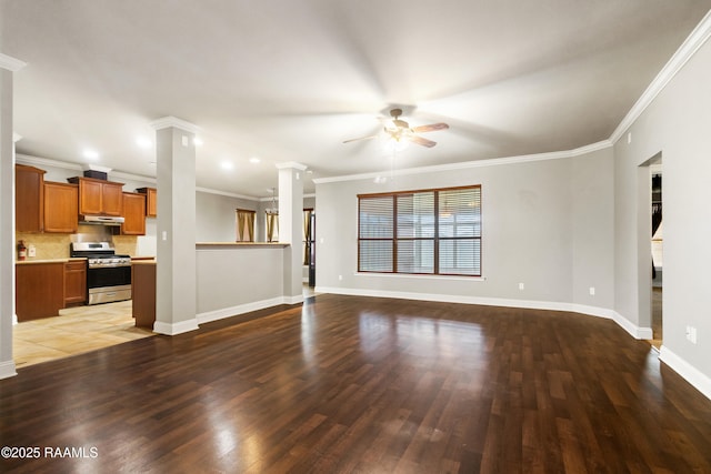 unfurnished living room with baseboards, ornamental molding, a ceiling fan, ornate columns, and wood finished floors