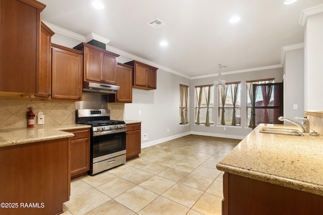 kitchen with tasteful backsplash, under cabinet range hood, visible vents, stainless steel range with gas stovetop, and a sink