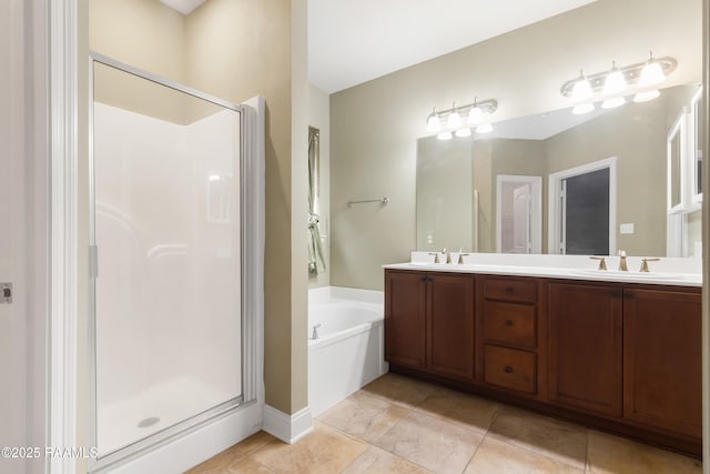 bathroom with a shower stall, a garden tub, and a sink