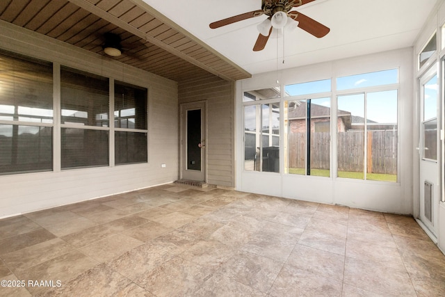 unfurnished sunroom featuring a ceiling fan