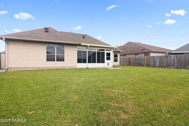 back of house with a yard, a fenced backyard, a shingled roof, and a sunroom