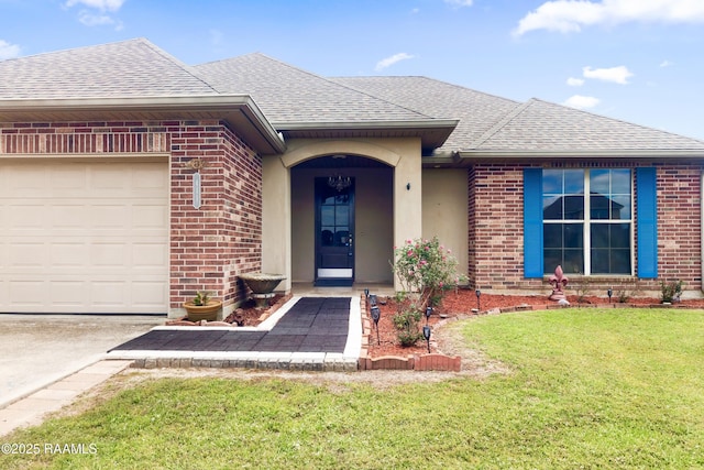 entrance to property featuring a lawn, a shingled roof, a garage, and brick siding