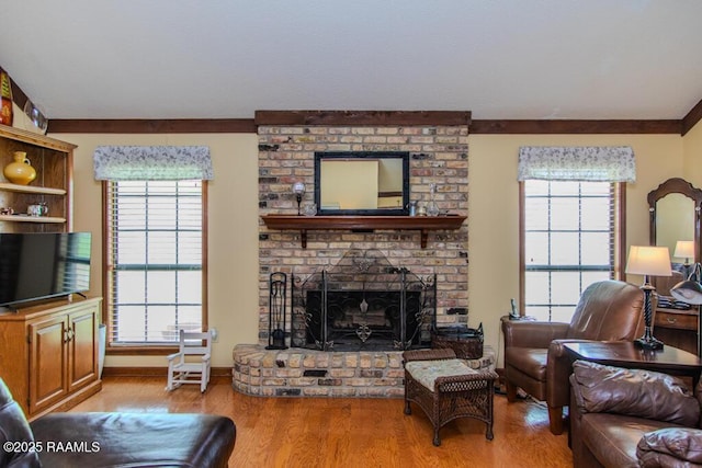 living area featuring a healthy amount of sunlight, ornamental molding, and wood finished floors