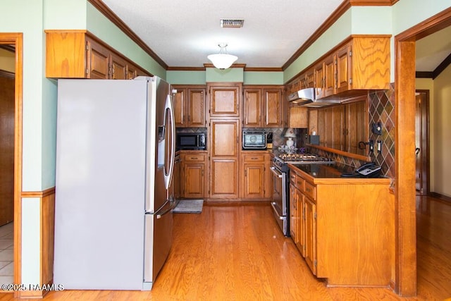 kitchen featuring visible vents, light wood-style floors, brown cabinets, crown molding, and stainless steel appliances