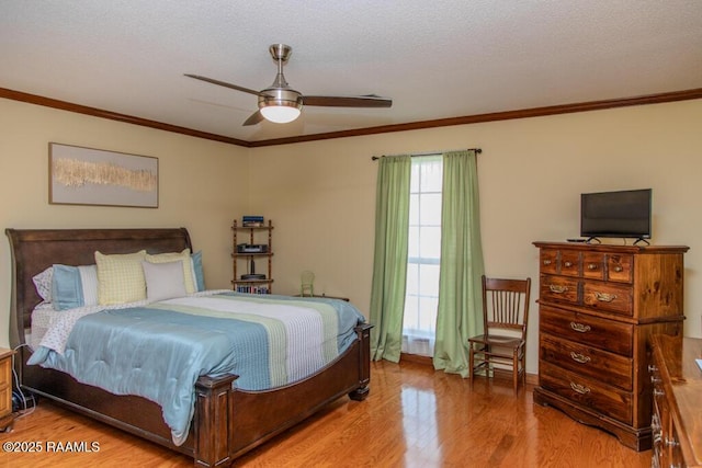 bedroom with light wood-style floors, a textured ceiling, crown molding, and a ceiling fan