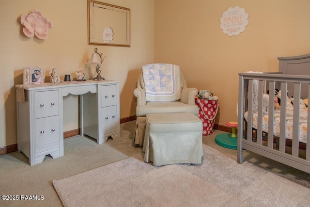 bedroom with a nursery area, baseboards, and light colored carpet