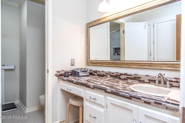 bathroom featuring tile patterned floors, vanity, baseboards, and toilet