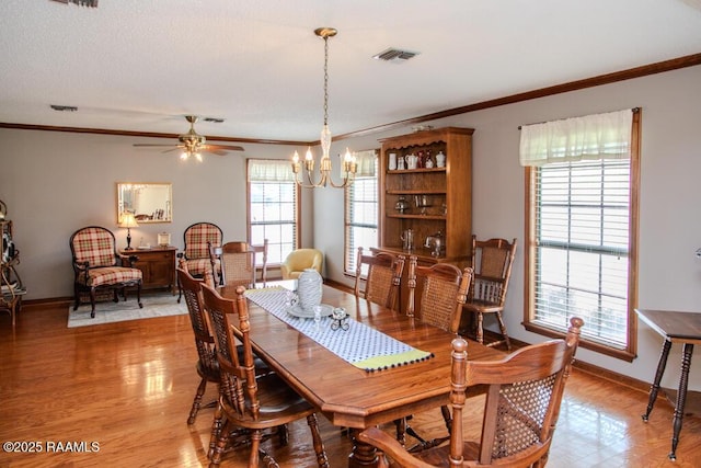 dining area with ornamental molding, visible vents, baseboards, and light wood-type flooring