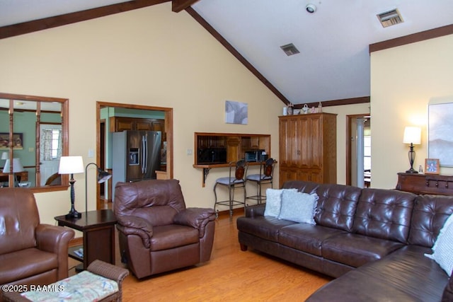 living area with a healthy amount of sunlight, light wood finished floors, and visible vents